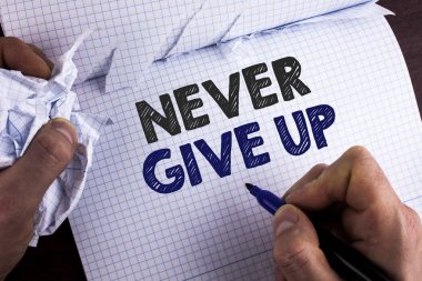 Word writing text Never Give Up. Business concept for Be persistent motivate yourself succeed never look back written by Man on Tear Nootbook Book holding Marker on wooden background. clipart