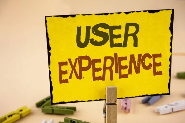 Handwriting text writing User Experience. Concept meaning Customer experience feedback web infrastructure development written on Yellow Sticky Note Paper on the plain background Wooden Clips.