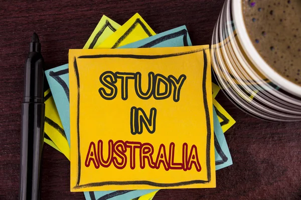 Uwaga: pisanie Wyświetlono badania w Australii. Biznesowe zdjęcie prezentujący absolwent z uniwersytetów zamorski napisany na papierze notatki na podłoże drewniane, filiżanki kawy i Marker świetna okazja — Zdjęcie stockowe