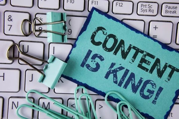 Handwriting text Content Is King Motivational Call. Concept meaning Strategy online internet digital seo written on Sticky Note paper placed on white Keyboard Clips and Paper Pins next to it.