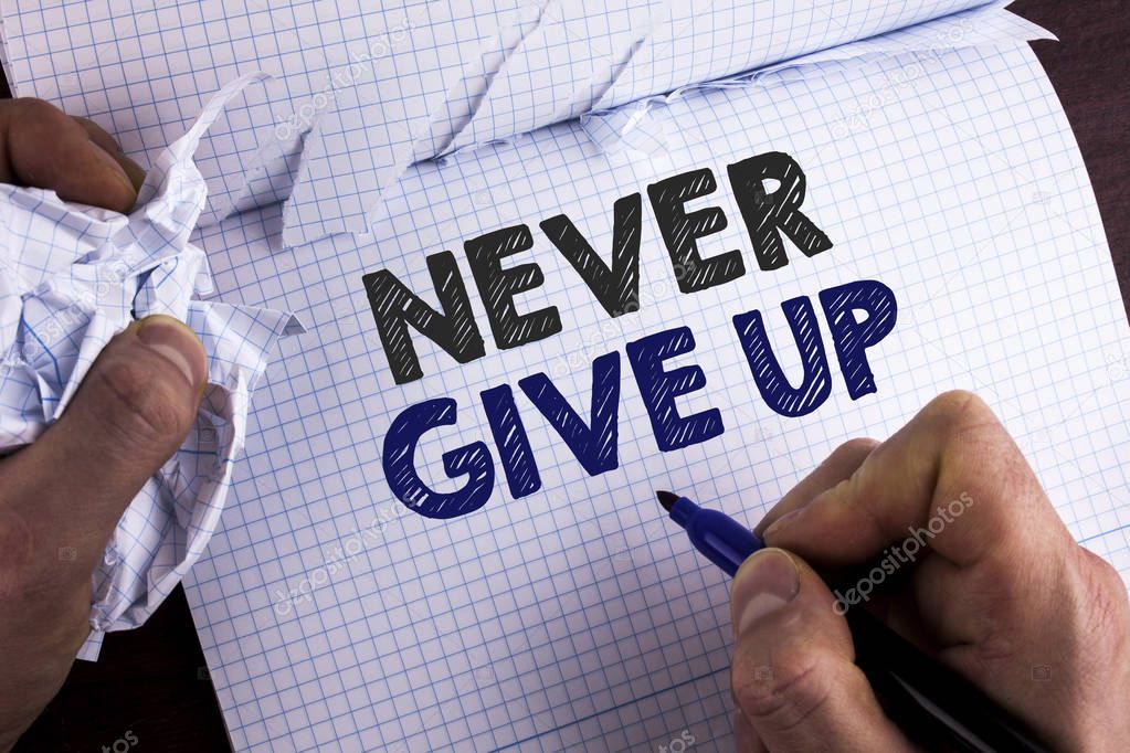 Word writing text Never Give Up. Business concept for Be persistent motivate yourself succeed never look back written by Man on Tear Nootbook Book holding Marker on wooden background.
