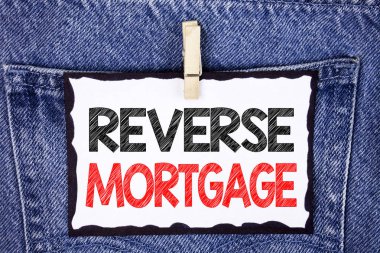 Ters ipotek gösterilen metin işareti. Kavramsal fotoğraf yaşlı ev sahibi emeklilik seçenek düzenli ödeme parası ile klip üzerinde kot arka plan asılı beyaz yapışkan not kağıt üzerinde yazılı.