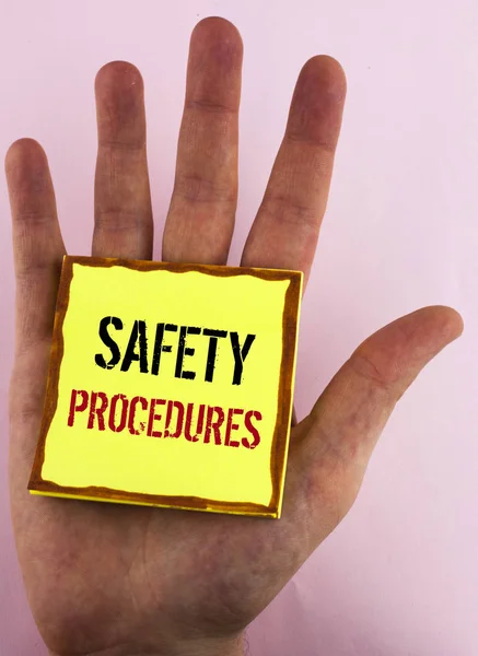 Szöveg jel bemutatás biztonsági eljárásokat. Fogalmi fénykép követ szabályok és rendeletek a sárga ragadós jegyzék papír forgalomba a kezét a sima háttérben munkahelyi biztonság. — Stock Fotó