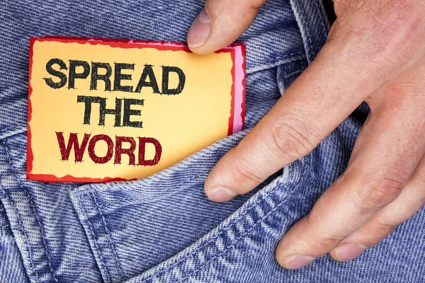 Tulisan kata Spread The Word. Bisnis konsep untuk Jalankan iklan untuk meningkatkan penjualan toko banyak kali lipat ditulis pada Sticky Note Kertas memegang oleh manusia di latar belakang Jeans . — Stok Foto