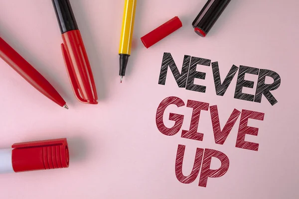 Концептуальный почерк, показывающий Никогда не сдаваться. Будьте настойчивы мотивировать себя преуспеть никогда не оглядываться назад написано на простой розовый фон ручки и маркер рядом с ним . — стоковое фото