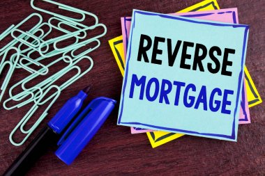 El yazısı metin ters ipotek. Kavram anlam yaşlı ev sahibi emeklilik seçenek düzenli ödeme parası ahşap arka plan Marker yapışkan not kağıdına ve ataç yanında yazılı.