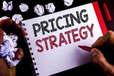 Fiyatlandırma stratejisi gösterilen not yazma. Pazarlama Satış Stratejileri kar promosyon kampanyası Marker ahşap arka plan kağıt topları tutan not etmek üstünde adam tarafından yazılmış vitrine iş fotoğraf