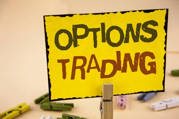 Handwriting text writing Options Trading. Concept meaning Options trading investment commodities stock market analysis written on Yellow Sticky Note Paper on the plain background Wooden Clips.