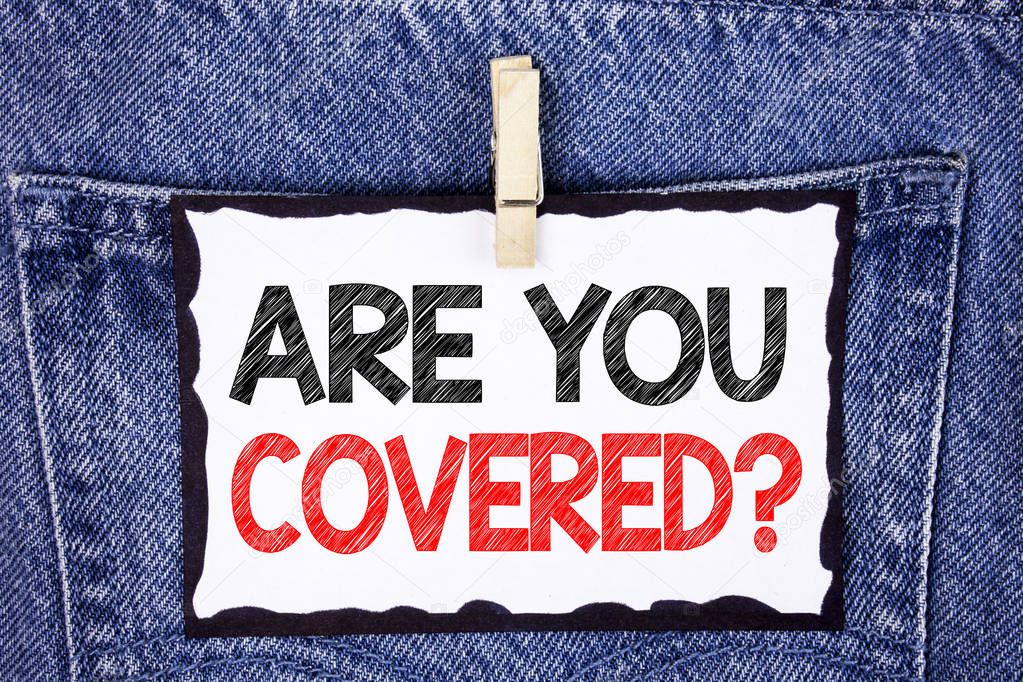 Text sign showing Are You Covered Question. Conceptual photo Health insurance coverage disaster recovery written on White Sticky Note Paper hanging with Clip on the Jeans background.