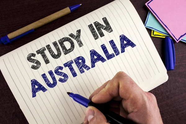 Kavramsal el çalışma içinde Avustralya gösterilen yazma. Yurtdışı üniversiteler büyük fırsat adam tarafından ahşap arka plan kalem defter kitap yazılmış dan mezun vitrine iş fotoğraf. — Stok fotoğraf