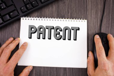 Patent gösterilen not yazma. Not etmek üstünde ahşap arka plan üzerinde klavye ve fare yanındaki yazılı bir ürün yapma satış kullanmak için haklar vermektedir lisans vitrine iş fotoğraf.