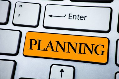 El yazısı metin planlama. Beyaz klavye turuncu anahtarını düğmesinde kopya alanı ile yazılı planlar yapma işlemi bir hedefe ulaşmak için stratejiler tanımlama anlam kavramı. Üstten Görünüm.