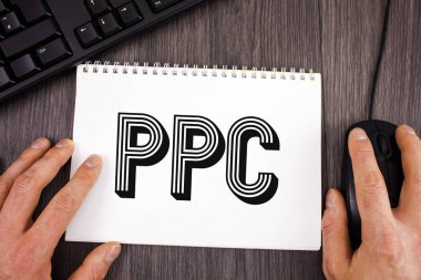 Ödeme başına tıklatın reklam stratejileri doğrudan trafik not etmek üstünde ahşap arka plan üzerinde klavye ve fare yanında yazılı web sitelerine vitrine Ppc. iş fotoğraf gösterilen not yazma.