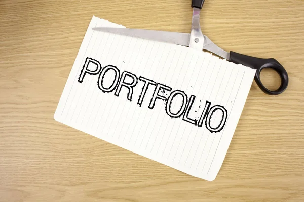 Conceptual hand writing showing Portfolio. Business photo text Examples of work used to apply for a job Combination of shares written on Tear Notebook Paper on wooden background Scissor.