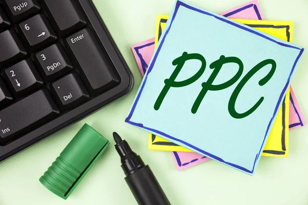 手写文字书写 Ppc. 概念意义每点击广告策略付费网站直接通信到写在纯绿色背景标记和键盘上的粘纸条纸上. — 图库照片