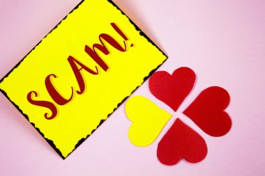 Aldatmaca motivasyonel ara gösterilen not yazma. Yapışkan not kağıdı düz pembe arka plan kağıt sevgi kalpleri üzerinde yazılı para kazanmak için dürüst olmayan hareket dolandırıcılık insanları kandırmak vitrine iş fotoğraf