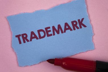 Ticari marka gösterilen not yazma. İş fotoğraf vitrine yasal telif hakkı fikri mülkiyet koruması düz pembe arka plan Marker gözyaşı mavi yapışkan not kağıdına yazılı kayıtlı.