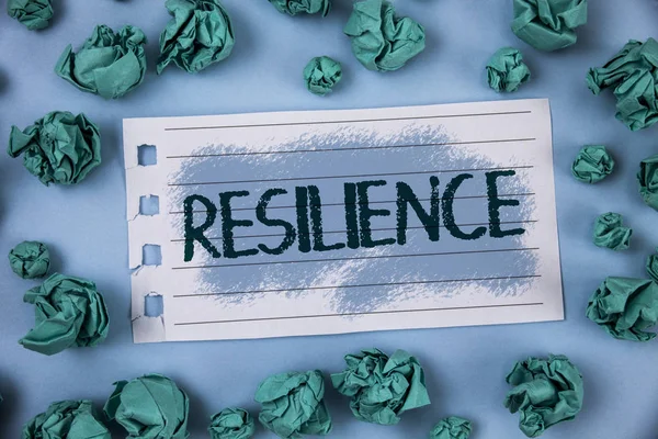 Signo de texto que muestra resiliencia. Foto conceptual Capacidad para recuperarse rápidamente de las dificultades Persistencia escrita en papel de bloc de notas dentro del Libro Verde Bolas sobre fondo azul liso . — Foto de Stock