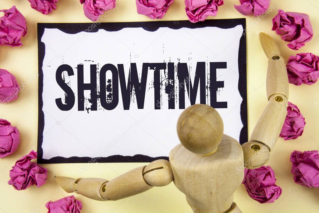 Handwriting text Showtime. Concept meaning Time a Play Film Concert Performance Event is scheduled to start written on Sticky Note Paper within Paper Balls on plain background Wooden Robot Toy.