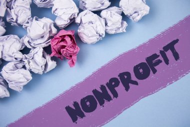 Word metin yazma Nonprofit. Boyalı arka plan buruşuk kağıt topları yanındaki yazılı executor için gelirleri elde edebilirim faaliyetleri için iş kavramı.
