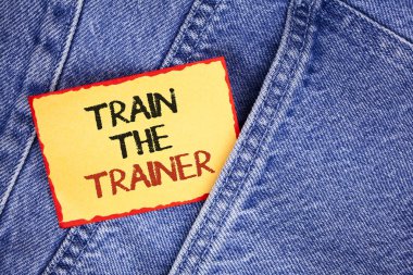 Tren eğitmen gösterilen not yazma. Öğrenme tekniği öğretmenler kendileri yapışkan not kağıdına kot arka plan üzerinde yazılı olan öğrenci showcasing iş fotoğraf.