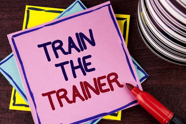Word metin tren antrenör yazma. İş kavramı öğrenme tekniği öğretmenler kendileri üzerinde pembe bir yapışkan not kağıdına ahşap arka plan Kupası ve damgalı yanında yazılı olan öğrenciler için