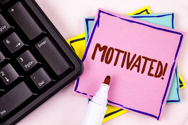 Text sign showing Motivated Motivational Call. Conceptual photo Willing to do something Inspired Confident written on Pink Sticky Note paper on plain background Marker and Black Keyboard.