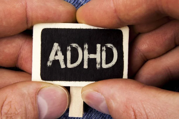 Escrevendo nota mostrando Adhd. Foto de negócios mostrando Aprendizagem facilitada para crianças que não ensinam mais uma tarefa difícil escrita em madeira Pedaço segurando por homem no fundo de calça azul . — Fotografia de Stock