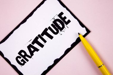 Handwriting text Gratitude. Concept meaning Quality of being thankful Appreciation Thankfulness Acknowledge written on White Sticky note paper on plain Pink background Pen next to it. clipart