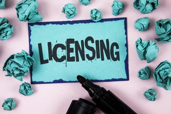 Word tekst intoetsen Licensing. Bedrijfsconcept voor toekenning van een licentie wettelijk het gebruik toestaan van iets toestaan activiteit geschreven op notitie papier op effen roze achtergrond papier ballen en markering. — Stockfoto