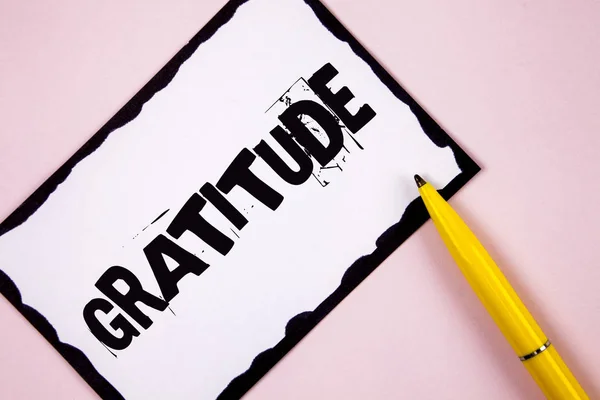 Scrivere un testo Gratitudine. Concetto significato Qualità di essere grati Ringraziamento Ringraziamento Riconoscimento scritto su carta nota appiccicoso bianco su sfondo semplice rosa Penna accanto ad esso . — Foto Stock