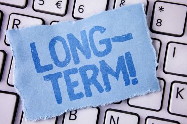 Word metin uzun vadeli motivasyonel ara yazma. Gelecek gözyaşı yapışkan not kağıt parçası üzerinde yazılı planlar iş kavramı Occurring büyük süre için beyaz klavyede yerleştirilir. Üstten Görünüm.