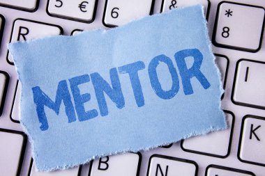 Metin akıl hocası yazılı kelime. İş kavramı bir genç daha az deneyimli gözyaşı yapışkan not kağıt parçası üzerinde yazılı için tavsiye ya da destek veren kişi için beyaz klavyede yerleştirilir. Üstten Görünüm.