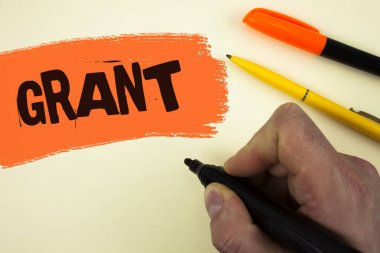 Grant gösterilen not yazma. Bir amaca burs boyalı arka plan kalemlerinde yanında bulunan işaret tutan adam tarafından yazılmış bir Örgütü ya da hükümet tarafından verilen para vitrine iş fotoğraf.