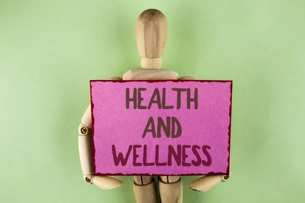 Handwriting text writing Health And Wellness. Concept meaning being in good shape Healthy food workout drink water written on Sticky note paper holding by Wooden Robot Toy on plain background. — Stock Photo, Image