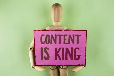 İçerik kral olduğunu yazma el yazısı metin. Kavram anlam makaleler veya mesaj reklam başarı tutmak ahşap Robot oyuncak tarafından düz arka plan üzerinde yapışkan not kağıt üzerinde yazılı garanti edemez.