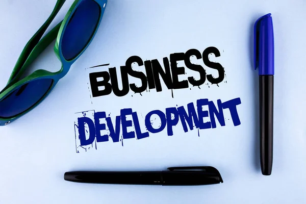 Conceptual hand writing showing Business Development. Business photo showcasing Develop and Implement Organization Growth Opportunities written on plain background Markers Sun Glasses next to it. — Stock Photo, Image