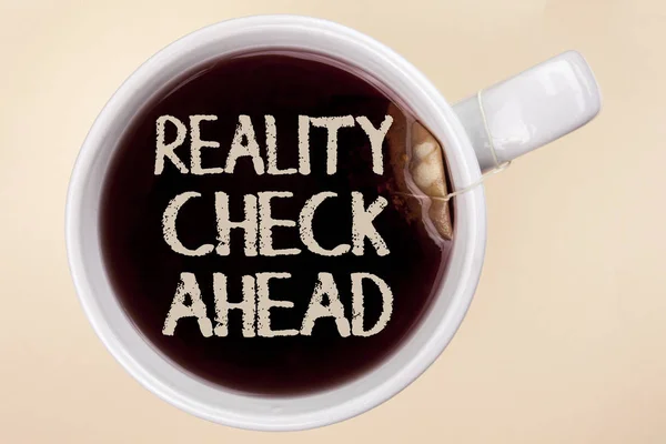 Handwriting text writing Reality Check Ahead. Concept meaning Unveil truth knowing actuality avoid being sceptical written on Tea in a Cup on the plain background Tea Bag.