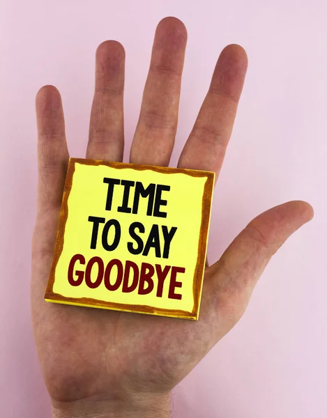 Word tekst intoetsen Time To Say Goodbye. Businessconcept voor scheiding Moment verlaten uiteenvallen afscheid wensen eindigend geschreven op kleverige nota papier geplaatst op de Hand op de vlakte achtergrond. — Stockfoto