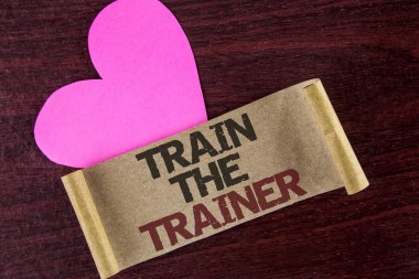 Tren eğitmen gösterilen not yazma. Öğrenme tekniği öğretmenler kendileri yanında ahşap zemin kalp üzerine karton kağıt üzerinde yazılı olan öğrenci showcasing iş fotoğraf.