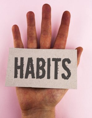 Kavramsal el yazma alışkanlıkları gösterilen. İş fotoğraf metin normal eğilim veya uygulama rutin her zamanki görgü davranış karton el düz arka plan üzerine yerleştirilen parçası üzerinde yazılı desen.