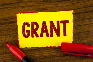 El yazısı metin Grant. Bir amaç ahşap arka plan Marker yanındaki sarı yapışkan not kağıdına yazılı burs için bir organizasyon veya hükümet tarafından verilen para anlam kavramı.