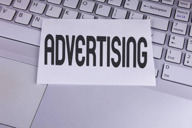 Kavramsal el gösterilen reklam yazma. Beyaz yapışkan not kağıdına yazılı dijital pazarlama optimizasyonu ile marka dünya dışarı ulaşmak vitrine iş Fotoğraf Laptop yerleştirilir.