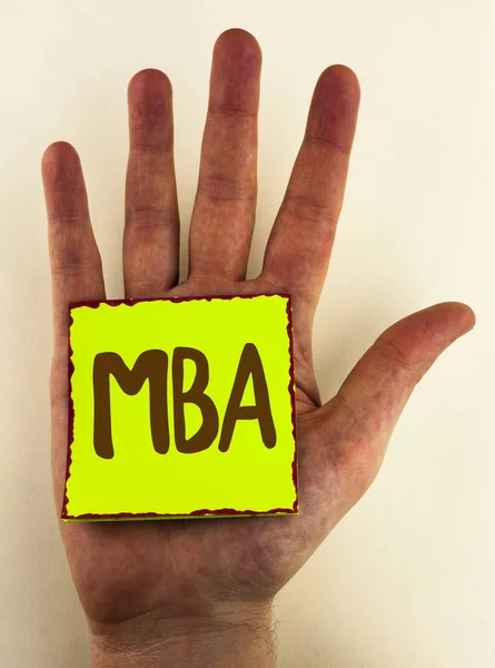 Escritura de texto a mano Mba. Concepto que significa Master of Business Administration Advance Degree After College Studies escrito en Sticky Note Paper colocado en la mano sobre el fondo liso . — Foto de Stock