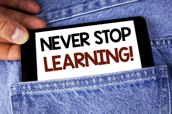 Escritura manual conceptual que muestra Never Stop Learning Motivational Call. Texto de la foto de negocios Manténgase educado Mejore las habilidades escritas en el teléfono móvil celebración por el hombre en el fondo Jeans . —  Fotos de Stock