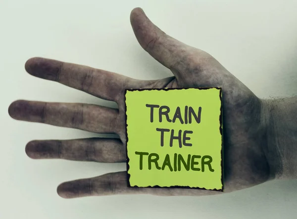 Írásbeli Megjegyzés mutatja Train The Trainer. Bemutatják a tanulási technika diákok, tanárok, magukat helyezni a piszkos kezét tisztán látható háttér Sticky Megjegyzés papírra írt, hogy üzleti fotó. — Stock Fotó