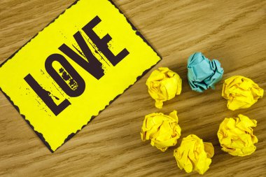 El yazısı metin aşk. Kavram anlamı yoğun duygu derin sevgi romantik cinsel eki ahşap arka plan buruşuk kağıt topları yanında yapışkan not kağıdına yazılı ilişki.