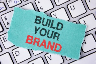 Build Your marka yazma el yazısı metin. Konsept Model reklam E yazılı pazarlama kendi logo sloganı oluşturmak anlamına gelen yapışkan not kağıt üstünde Laptop yerleştirilen gözyaşı.