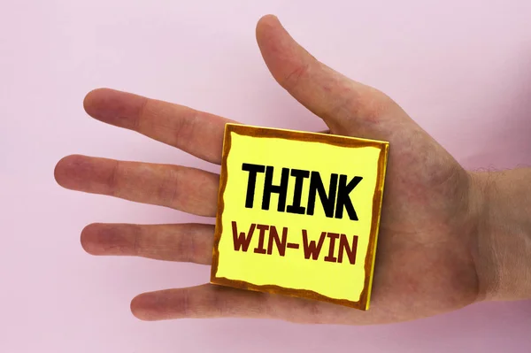 Написання тексту почерком Think Win-Win. Концепція означає Стратегія переговорів для обох партнерів, щоб отримати переваги, написані на папері Sticky Note, розміщеній на руці на звичайному тлі . — стокове фото