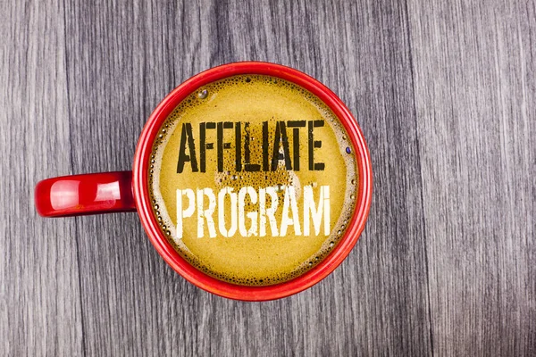 Writing note showing  Affiliate Program. Business photo showcasing software link songs apps books and sell them to earn money written on Coffee in Red Cup on the Grey wooden background. Top view.